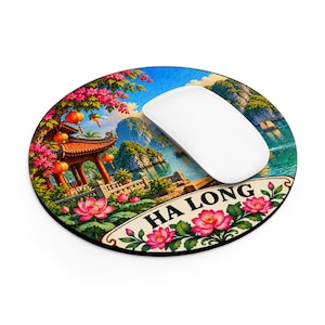 May include: A round mouse pad featuring a vibrant illustration of Ha Long Bay with a traditional pavilion, orange lanterns, pink lotus flowers, and blue water. The text HA LONG is printed in black on a cream-coloured banner at the bottom.