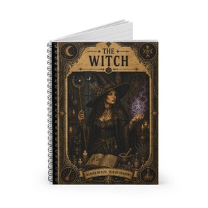 May include: Spiral-bound notebook featuring a detailed illustration of a witch. The cover displays the text "THE WITCH" above an image of a woman in a witch's hat, holding a staff and a glowing orb. The bottom banner reads "WEAVER OF FATE, SEER OF SHADOWS."