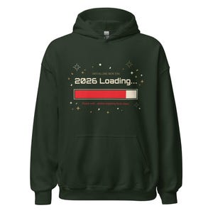 Op de afbeelding: Donkergroene hoodie met lange mouwen. De voorkant toont de tekst "INSTALLING NEW ERA" boven "2026 LOADING..." met een laadbalk. Daaronder staat de tekst "Please wait... system preparing fresh chaos."