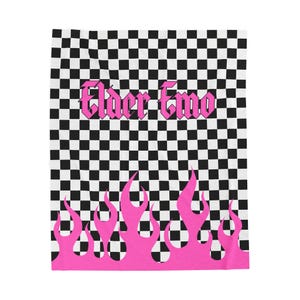 May include: A black and white checkered textile with the words "Elder Emo" in pink gothic lettering. Pink flames are at the bottom of the textile. The textile is rectangular.