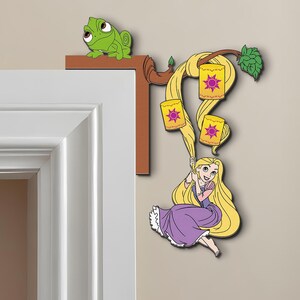 May include: A decorative wall accent featuring a cartoon of a girl with long blonde hair swinging from lanterns. A green chameleon sits on a brown ledge. The girl wears a purple dress. The lanterns have a purple sun design.