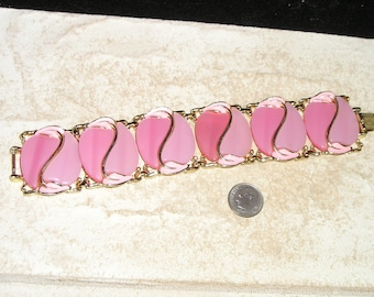 May include: A pink and gold bracelet with a series of oval-shaped pink glass stones set in gold metal. The stones have a swirl design and are connected by a gold chain.