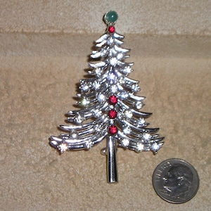 Puede incluir: Broche de árbol de Navidad de plata con diamantes de imitación rojos y verdes.
