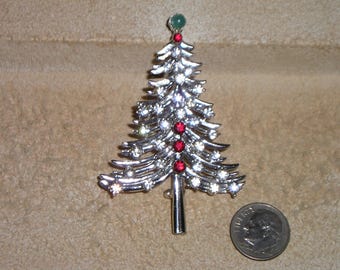May include: Silver Christmas tree brooch with red and green rhinestones.