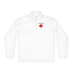 May include: White long-sleeve pullover with a quarter-zip collar. Features a red maple leaf graphic and the word "CANADA" in black text above the leaf. Below the leaf is the text "EST. 1867".