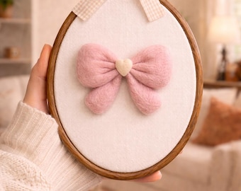 Bastidor de bordado com laço rosa em formato de coração, feito à mão com feltro agulhado, em lã macia para pendurar na parede.