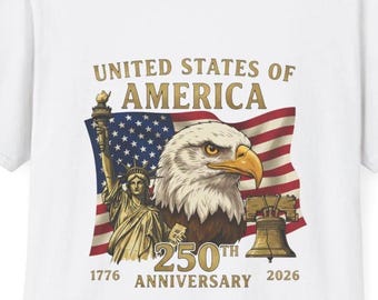 May include: White t-shirt featuring a patriotic design for the United States of America's 250th anniversary. The graphic includes an eagle, the Statue of Liberty, a flag, and a bell. The text reads "United States of America" and "250th Anniversary 1776-2026."