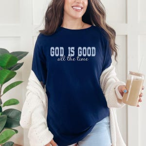 Navy blue Christian graphic tee “God is good all the time” styled with cardigan and coffee, cozy casual outfit, faith based clothing for women