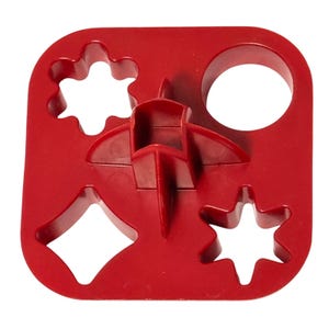May include: A red plastic multi-shape cutter featuring four distinct cutouts: a six-pointed flower, a circle, a four-pointed diamond, and a six-pointed star. The tool has a central raised handle structure with four perpendicular fins for gripping.