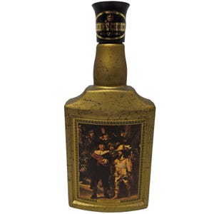 May include: A gold-colored decanter bottle with a textured finish and a black stopper. The neck label reads BEAM'S CHOICE 4/5 QUART. The front features a rectangular framed reproduction of a group of figures in historical attire, resembling a painting.