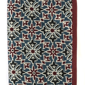 May include: A burgundy fabric pencil case with a blue and white floral pattern. The case has a zipper closure and a small loop for hanging.