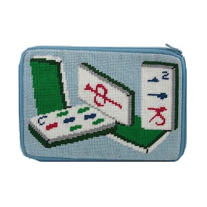 May include: A blue zippered pouch with a needlepoint design of mahjong tiles. The tiles are in a variety of colors, including red, green, and blue. The pouch is perfect for storing small items like jewelry or coins.