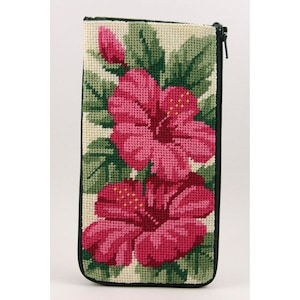 May include: A needlepoint zippered pouch with a floral design featuring pink hibiscus flowers and green leaves on a cream background.