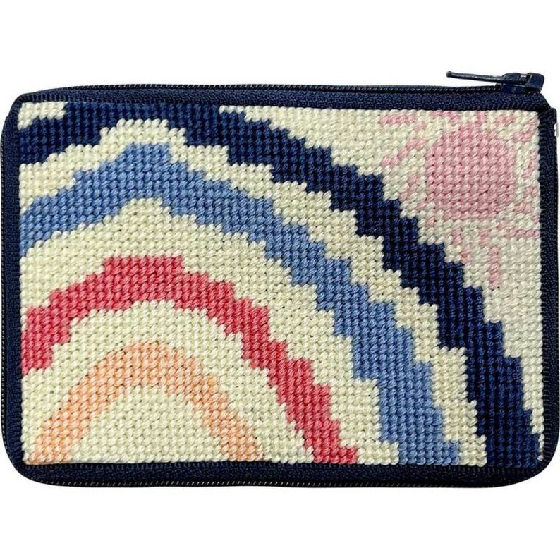 May include: A small zippered pouch with a colorful rainbow design. The pouch is made of needlepoint fabric and has a navy blue border.