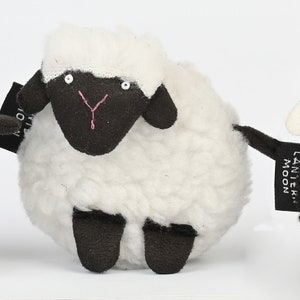 May include: Three plush sheep toys, one gray, one white, and one black. Each sheep has a black face with white eyes and a pink nose.