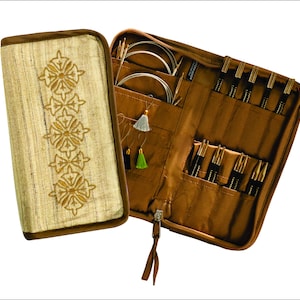 May include: A brown zippered case with a beige fabric exterior featuring an embroidered design. The case is open to reveal a set of knitting needles and circular needles in various sizes. The case also includes a small pocket with a few stitch markers.