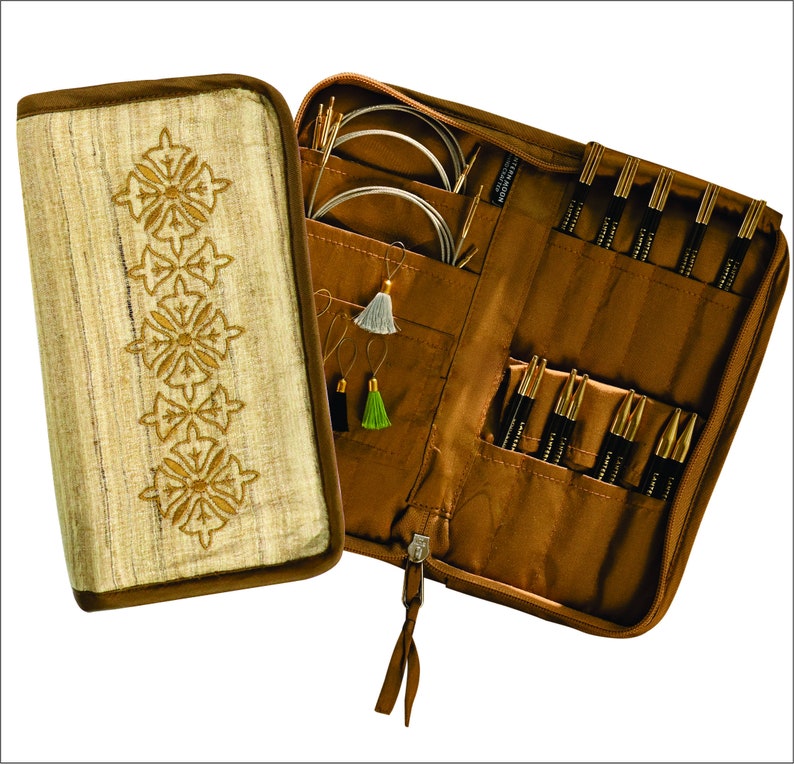 May include: A brown zippered case with a beige fabric exterior featuring an embroidered design. The case is open to reveal a set of knitting needles and circular needles in various sizes. The case also includes a small pocket with a few stitch markers.