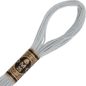 May include: A skein of light blue DMC 25 embroidery floss. The label is brown and black with the DMC logo and text. The floss is 8 m (8.7 yd) in length. The floss is looped at the top.