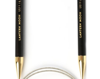 Könnte beinhalten: Ein schwarzes und goldenes Rundstricknadel-Set mit einem Kabel. Die Nadeln sind mit "LANTERN MOON US11/8.0mm" beschriftet.