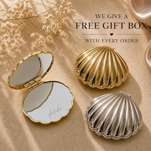 May include: Three shell-shaped compact mirrors with metallic finishes. One gold mirror is open, revealing a reflective surface with the script text Koko. Two closed mirrors, one gold and one silver, display a ribbed, scalloped exterior design.
