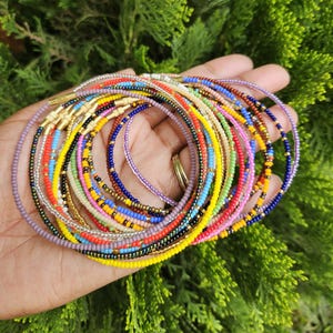 Puede incluir: Una taza de cerámica blanca con un asa negra y el texto "But First, Coffee" en negro y negrita. La taza está sobre una superficie blanca. La taza mide aproximadamente 10 cm de alto.