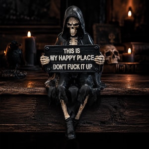 May include: A black-robed skeleton figurine sitting and holding a rectangular sign with the white text: THIS IS MY HAPPY PLACE DON'T FUCK IT UP. The figure features a hooded cloak, skeletal hands, and exposed bone legs with black boots.