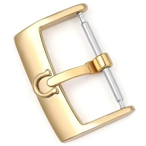 May include: A gold-coloured watch buckle with a polished finish. The buckle has a rectangular frame with a curved hook and a silver-coloured pin for securing a watch strap. The design is simple and elegant.