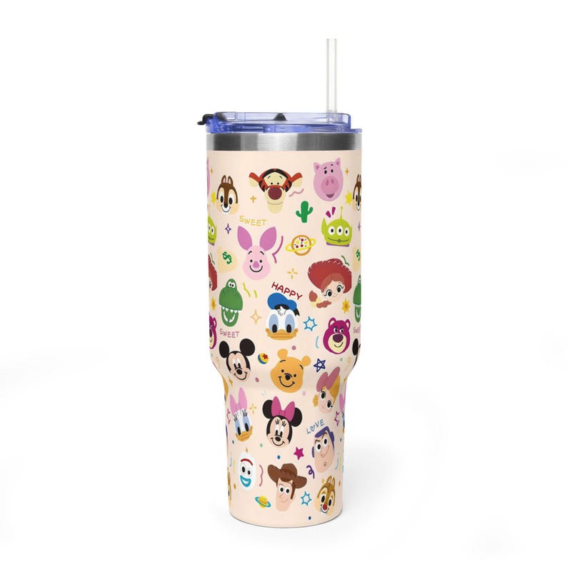 Puede incluir: Un vaso de acero inoxidable de color beige claro con tapa transparente y pajita, que presenta un patr&oacute;n repetitivo de caras de personajes de dibujos animados coloridos, estrellas peque&ntilde;as y las palabras SWEET, HAPPY y LOVE impresas.