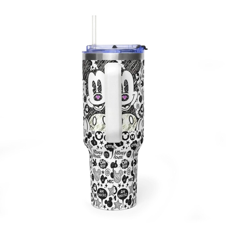 May include: A stainless steel tumbler with a handle, a clear lid, and a straw. The exterior features a black and white sketch-style pattern of Mickey Mouse faces, stars, and text including "Oh Boy," "Mickey Mouse," and "Aw Shucks" with pink heart accents.