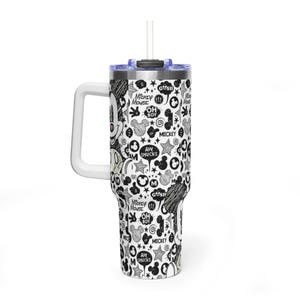 May include: A white stainless steel tumbler with a handle and a clear lid featuring a straw. The exterior is covered in a black and white doodle-style pattern of Mickey Mouse faces, stars, and speech bubbles with text including Mickey Mouse, Oh Boy, and Aw Shucks.