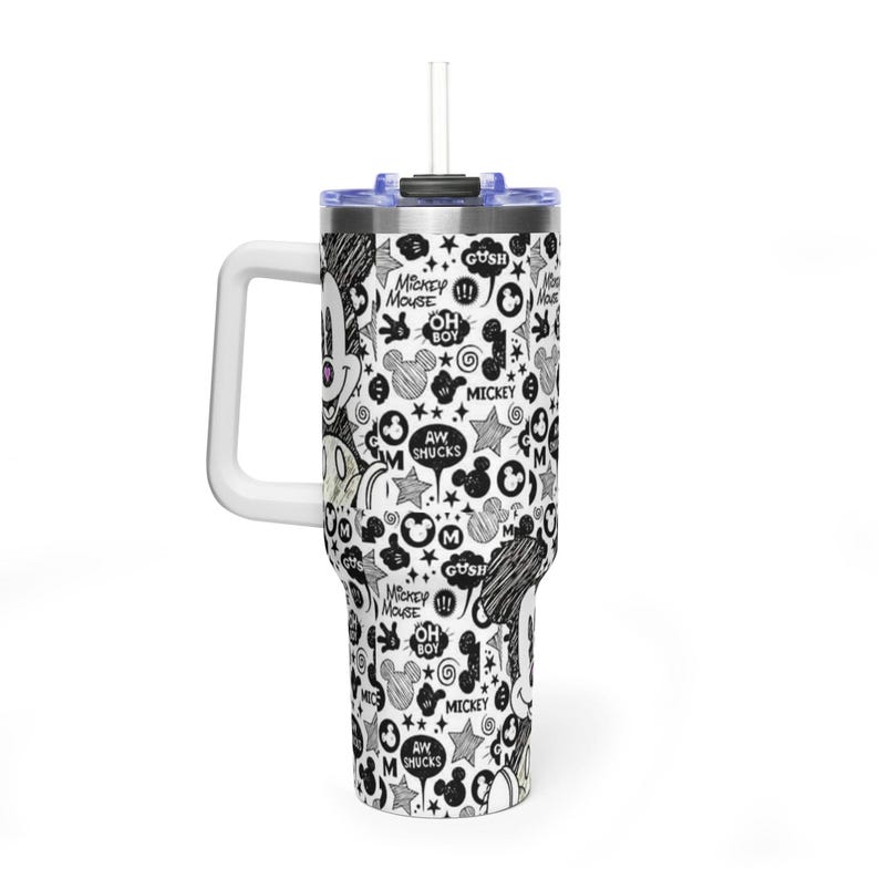 May include: A white stainless steel tumbler with a handle and a clear lid featuring a straw. The exterior is covered in a black and white doodle-style pattern of Mickey Mouse faces, stars, and speech bubbles with text including Mickey Mouse, Oh Boy, and Aw Shucks.
