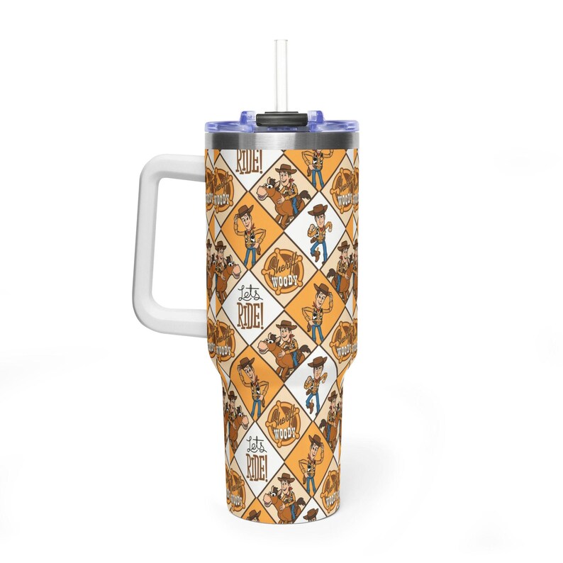 Puede incluir: Un vaso de acero inoxidable con asa blanca, tapa transparente y pajita. El exterior presenta un patr&oacute;n de rombos en naranja y blanco, decorado con ilustraciones de un vaquero, caballos y el texto Let's Ride!