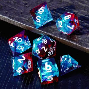 May include: Set of seven polyhedral dice with a vibrant mix of blue and red colors. Each die features white numbering. The dice are designed for tabletop role-playing games.