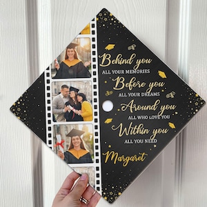 May include: A black graduation cap with gold text and star accents. The cap features three photos in a film strip design. Text on the cap reads "Behind you," "Before you," "Around you," and "Within you," along with the name "Margaret."