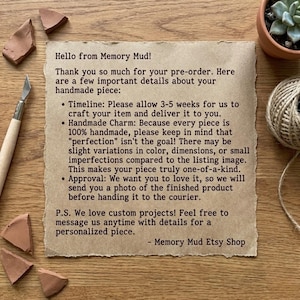 May include: A handwritten note from Memory Mud on aged paper, with text about handmade items, timelines, and approval processes. The note is surrounded by pottery shards, a craft knife, twine, and a small potted plant.