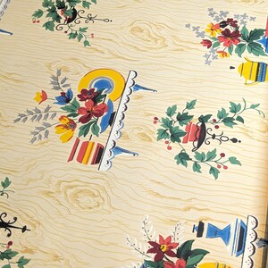 Puede incluir: Papel tapiz vintage con fondo de veta de madera y un patrón repetitivo de arreglos florales con acentos azules, rojos, amarillos y verdes. Los arreglos florales se colocan sobre mesas pequeñas con acentos blancos y azules.