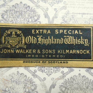 May include: A gold label with black text that reads "EXTRA SPECIAL Old Highland Whisky. JOHN WALKER & SONS KILMARNOCK (REGISTERED) PRODUCE OF SCOTLAND". The label features a crest with the words "CONFIDO GOLD W&S BERRY" and a stag.