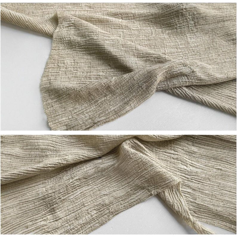 Puede incluir: Primer plano de una tela beige con una apariencia texturizada y arrugada. La tela est&aacute; doblada y drapeada, revelando el tejido detallado y sutiles variaciones de color. El material parece suave y ligero, adecuado para ropa o decoraci&oacute;n del hogar.