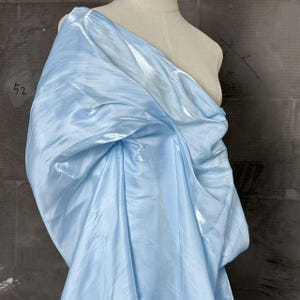 May include: A white ceramic mug with a black handle and the text "But First, Coffee" in a bold, black font. The mug is set against a neutral background, highlighting its simple design. The mug measures approximately 4 inches in height.