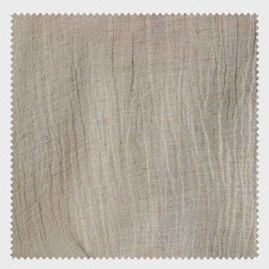May include: A square swatch of beige linen fabric with a textured, wrinkled appearance. The fabric has a raw, natural look with vertical lines and a jagged edge, suggesting it's cut from a larger piece.