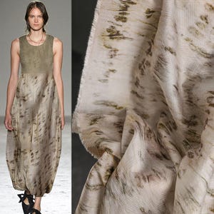 Puede incluir: Vestido sin mangas con corpi&ntilde;o verde oliva claro y falda fluida con estampado abstracto beige y marr&oacute;n. La tela tiene un aspecto suave y texturizado. A la derecha se muestra una muestra de la misma tela.
