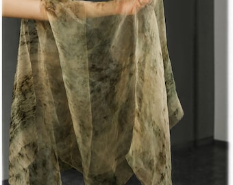 Puede incluir: Una bufanda transparente en tonos beige, verde oliva y marrón. La tela tiene un patrón veteado, similar a una acuarela. La bufanda se sostiene, mostrando su caída y textura, ideal para añadir un toque de elegancia.