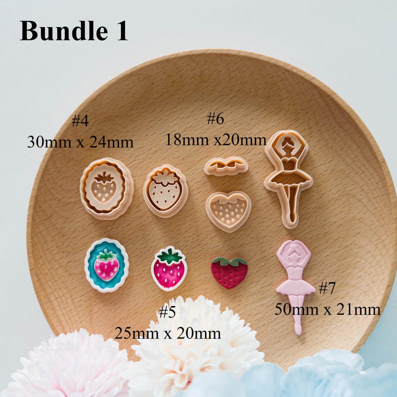 May include: A collection of cookie cutters in various shapes, including strawberries, hearts, and a ballerina. The cutters are in shades of pink, white, and brown. The text "Bundle 1" is at the top. Measurements are provided in millimeters.