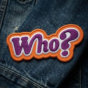 May include: Embroidered patch with the word "Who?" in purple, outlined in white, and set against an orange border. The patch is affixed to a blue denim jacket, creating a contrast of colors and textures.