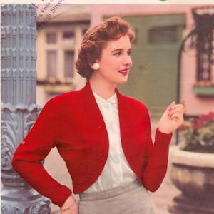 Könnte beinhalten: Ein roter Strickcardigan mit Schalkragen, langen Ärmeln und einem weißen Knopfverschluss. Der Cardigan wird von einer Frau mit einer weißen Bluse und einem grauen Rock getragen. Das Bild stammt aus einem Vintage-Strickmuster.