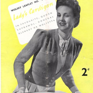 Op de afbeelding: Een vintage breipatroonboekje voor een trui, met een vrouw die het afgewerkte kledingstuk draagt. Het boekje heeft de titel "Lady's Cardigan" en is genummerd 455. De tekst vermeldt ook de garen soorten die worden aanbevolen voor het project: Quorn, Suprawol, Donegal, Glenroy en Wolvetta. De prijs is vermeld als 2d.