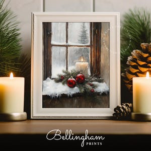 May include: A framed winter scene print featuring a window with a lit candle, red ornaments, and snow. The print is in a white frame. The Bellingham Prints logo is at the bottom.