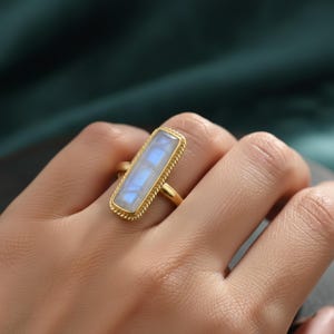 May include: A set of three ceramic mugs with a speckled, cream-colored glaze. Each mug features a different hand-painted floral design in shades of blue, green, and yellow. The mugs have a simple, rounded shape and a comfortable handle.