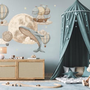 May include: A nursery scene with a light blue wall featuring a mural of a whale, hot air balloons, and a full moon. A wooden dresser, a canopy bed, and a stuffed giraffe complete the room's decor. The room is decorated with soft colours and a playful theme.