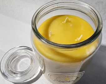 May include: A yellow three-wick candle in a clear glass jar with a matching glass lid. The candle wax is smooth and bright yellow. A label on the jar features the text Natural Light Candles with a small flame icon above the word Natural.